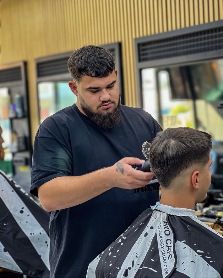 Frizer realizând o tunsoare